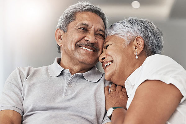 Love, relax and senior couple laugh at funny joke, enjoy quality time together and bond on home living room sofa. Retirement, smile and elderly man, woman or people happy in Rio de Janeiro Brazil