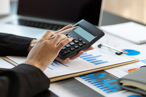 Financial planning and expense accounting concepts. Woman uses a calculator to calculate and audit.