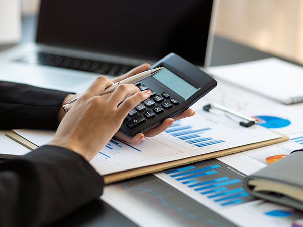 Financial planning and expense accounting concepts. Woman uses a calculator to calculate and audit.